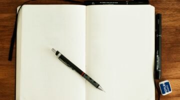 دفتر فارغ وأدوات كتابة في مشهد توضيحي للاستعداد للامتحانات