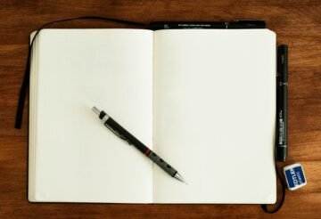 دفتر فارغ وأدوات كتابة في مشهد توضيحي للاستعداد للامتحانات