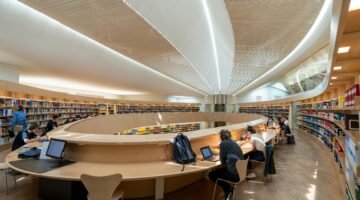 قاعة مكتبة عامة مع طلاب وكتب، صورة توضيحية للدراسة الجامعية